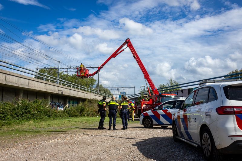 Rookontwikkeling over treinspoor door brandende scooter Rotterdam